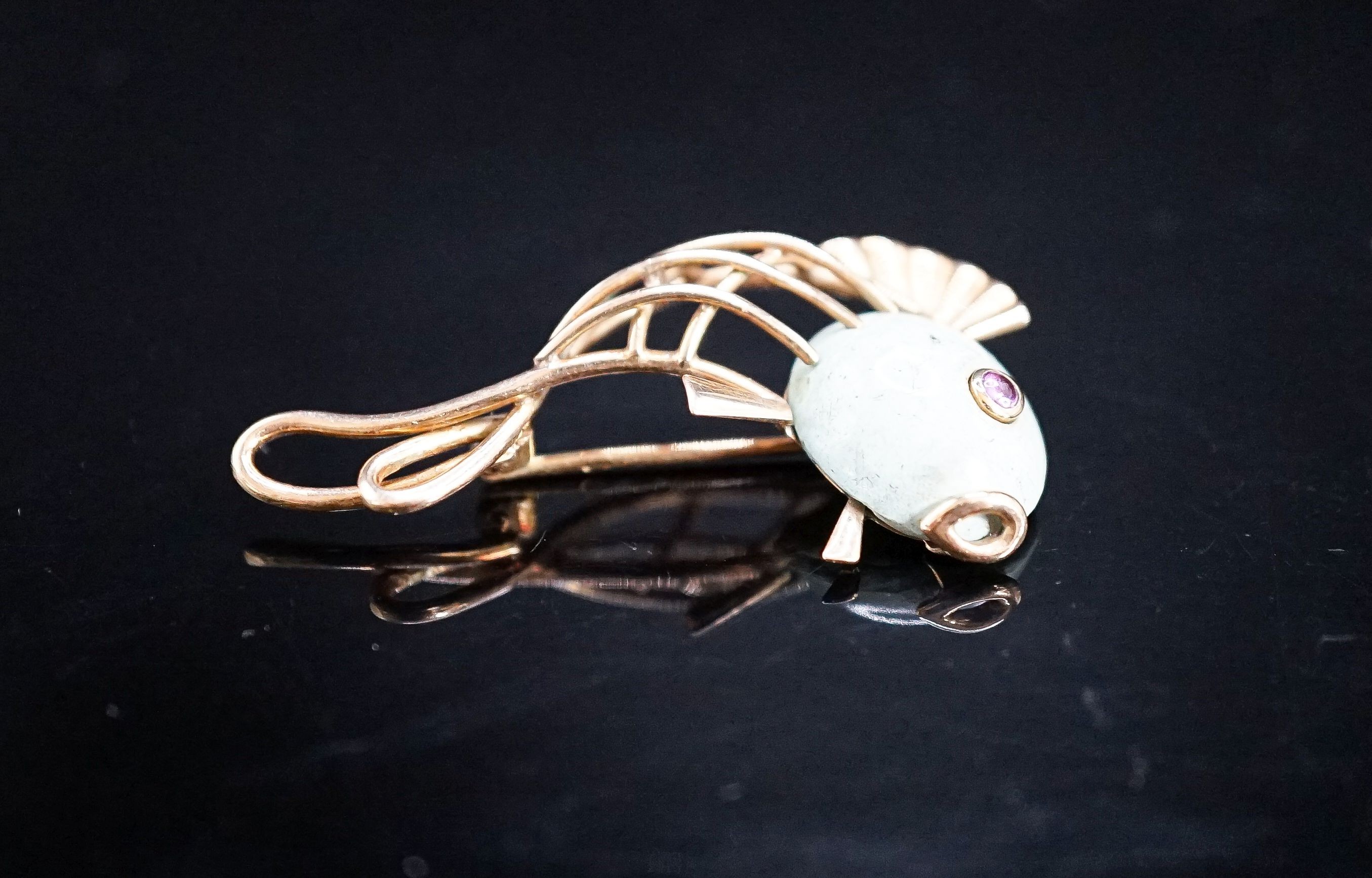 A Viennese 585 yellow metal, hardstone and cabochon ruby set brooch, modelled as a stylised fish, 39mm, gross weight 5.4 grams.